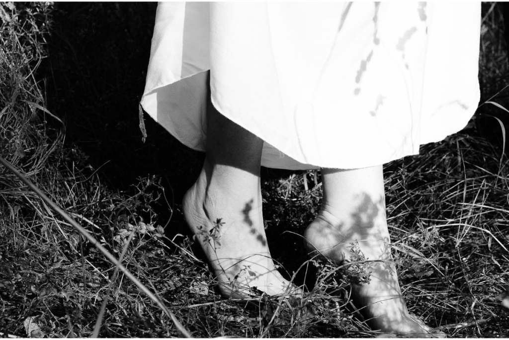 a woman's bare feet in a field of grass